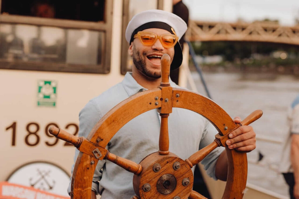 Party guest at the helm of the boat